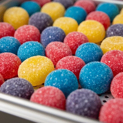 Close-up of freeze-dried candy being made, showing colorful candies in a freeze-dryer tray, no text, no words, no typography, clean image