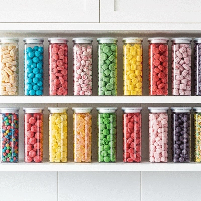 Assortment of colorful freeze-dried candies in clear, airtight containers, arranged neatly on a kitchen shelf, no text, no words, no typography, 8K