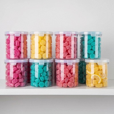 Assortment of colorful freeze-dried candies in clear airtight containers on a shelf